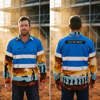 Man wearing a blue work shirt with a sunset design and 'Lest We Forget' text on the back, standing in front of scaffolding.