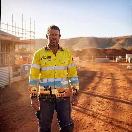 Man wearing a high-visibility work shirt with a colorful pattern on a construction site.